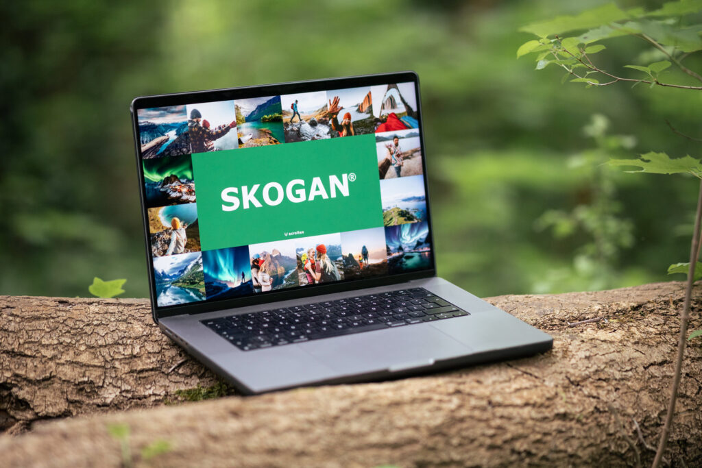 Webentwicklung von SKOGAN, dargestellt auf einem Laptop im Freien für dynamisches Nutzererlebnis.